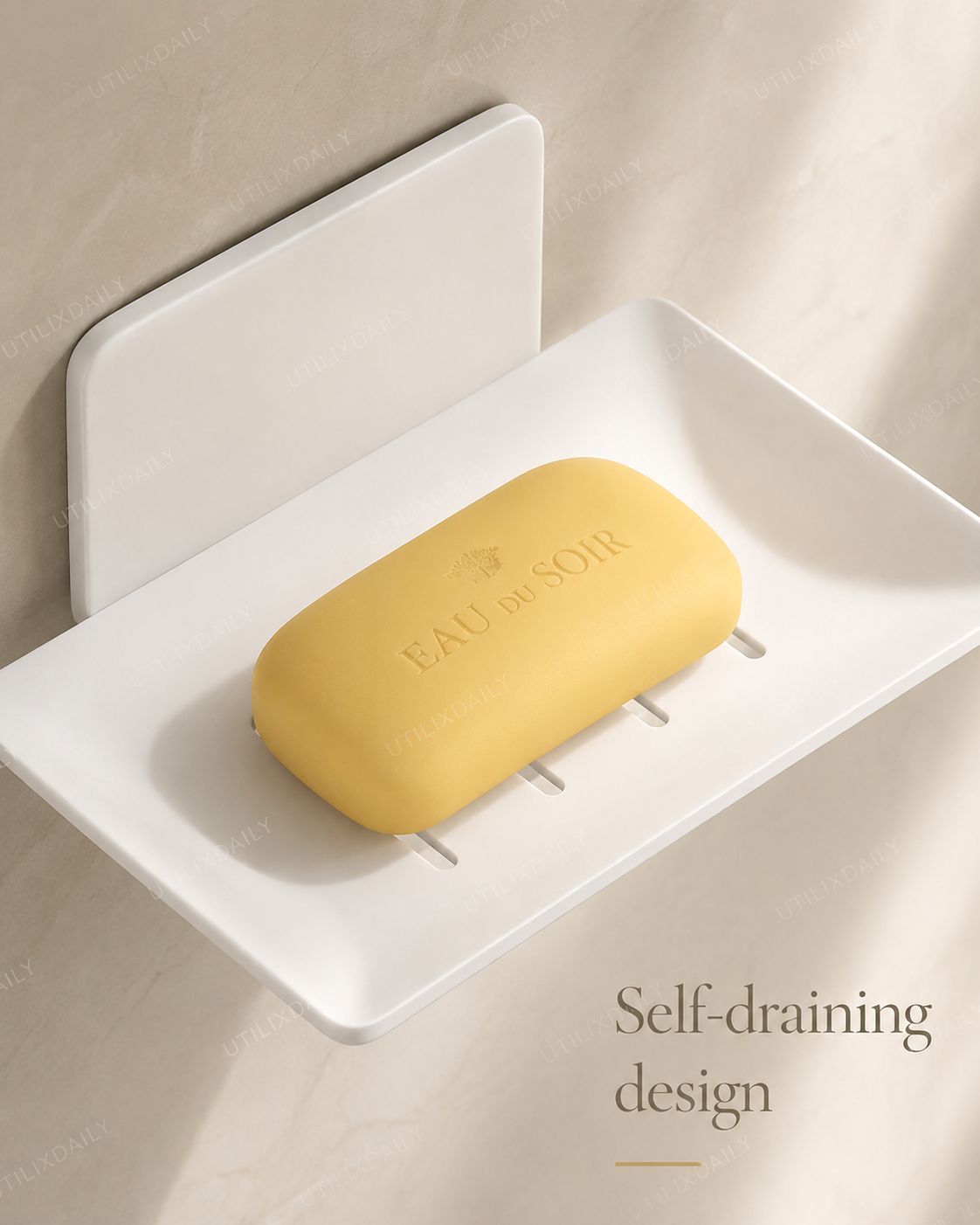 Close-up of a white self-draining wall-mounted soap holder showing the drainage slots and a yellow soap bar.