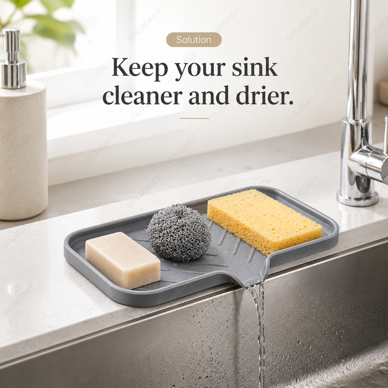 Grey silicone sink tray holding sponge, soap, and scrubber in an organized way beside a sink.